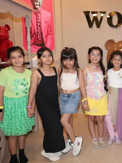 A group of friends hold hands and pose for a photo.