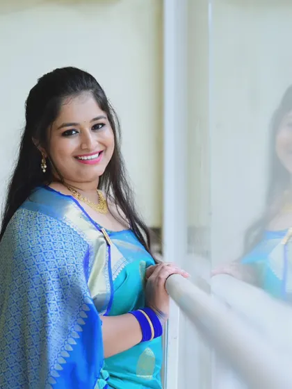 A happy client looking lovely in a blue banarasi silk saree, a timeless choice for any celebration.