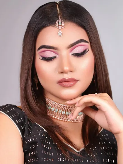 The soft, matte lip perfectly complements the vibrant pink eyes, creating a balanced and beautiful party look.