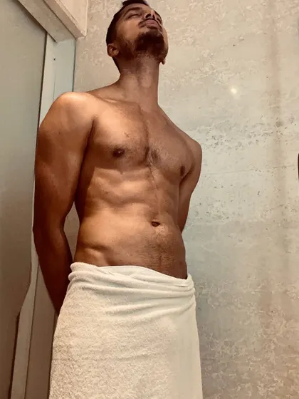 A moment of relaxation and deep breathing after a workout. The towel-draped look is classic for health and wellness campaigns.