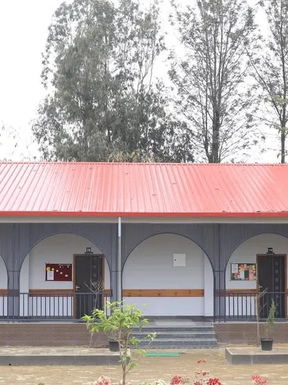 A frontal view of the completed primary block, highlighting the clean lines and the contrast between the white walls and dark arch details.