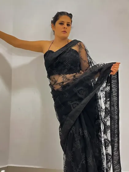 A full-lace black saree paired with a matching lace bandeau blouse. This look is all about texture and creating a daring, modern silhouette.