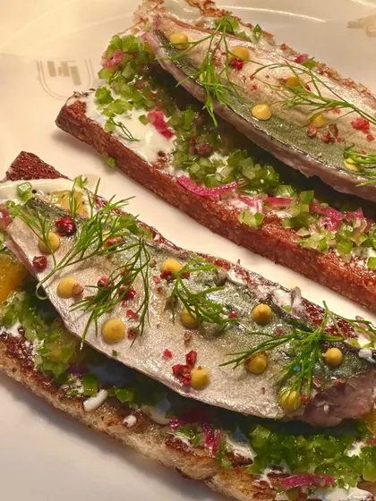 Our house-smoked Mackerel on Toast. This dish highlights our in-house capabilities, with delicately smoked fish served on crisp bread with fresh herbs and pickled elements for a burst of flavour.
