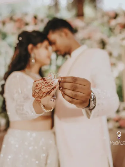 A creative shot focusing on the engagement rings, symbolizing the couple's union.