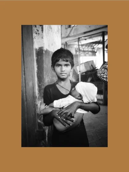 A poignant black and white photograph by a young artist from the "Inheritance" project, capturing a quiet moment of responsibility and care.
