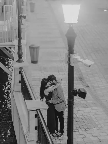 An intimate embrace under the soft glow of a streetlamp in Qatar. This black and white photo creates a timeless, cinematic feel for a destination pre-wedding shoot.