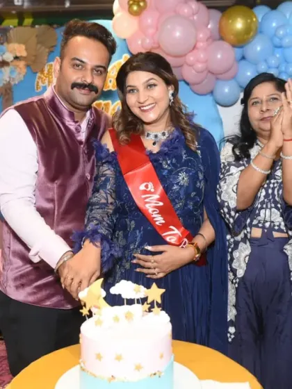 A candid shot of the couple and their family clapping and smiling during the cake cutting.