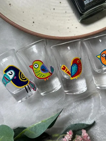 Our hand painted bird shot glasses lined up and ready for a party. This set includes a toucan and other tropical bird designs.