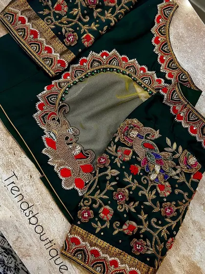 A closer look at the bottle green bridal blouse, showing the intricate 3D floral work, peacock motifs, and the sheer net back panel.
