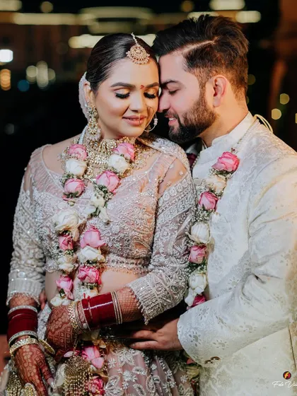 A close and loving embrace between the couple after their wedding ceremony, their floral garlands adding a touch of freshness.