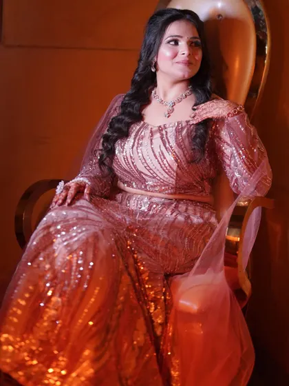 The bride seated and looking confident, her entire look exuding glamour and sophistication.