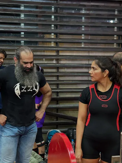 A candid moment discussing strategy with my coach during a meet. This is the level of focus and expert feedback you get when you train with me for a competition.