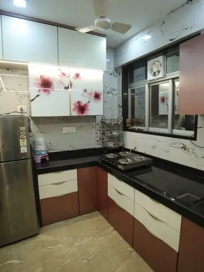 Even a small kitchen can be highly functional and stylish. This L-shaped kitchen uses profile shutters, digital glass, and a compact layout to make the most of the available space.