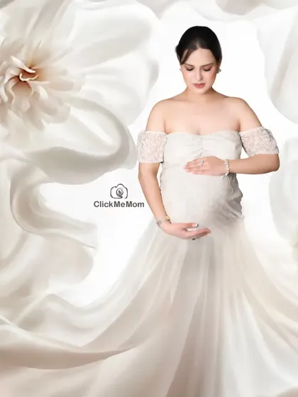 An angelic portrait surrounded by a cascade of white flowers and soft fabric. This high-key, brightly lit setup creates a pure, heavenly, and utterly timeless image of motherhood.