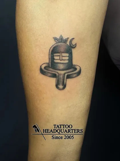 A minimalist Shiva Linga tattoo, shaded to give it a three-dimensional appearance, symbolizing divine energy.