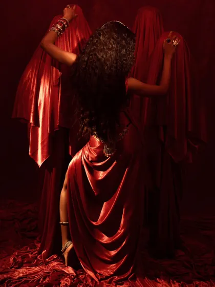 A back-facing shot that creates a dynamic, dance-like pose. It highlights the model's long, flowing hair and the way the jewelry moves with her body.