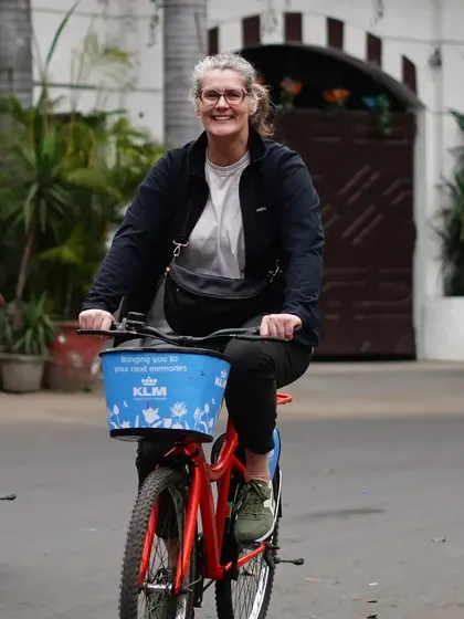 A happy rider pedals through a quiet neighborhood. Our tours are paced to be enjoyable for cyclists of all levels.
