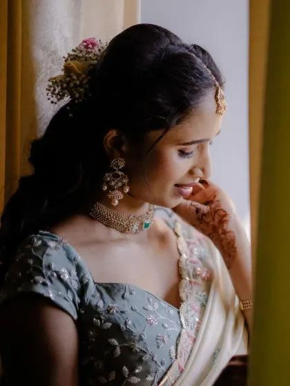 A beautiful side profile showcasing the soft hairstyle and the delicate jewellery. The makeup is all about enhancing her glow.