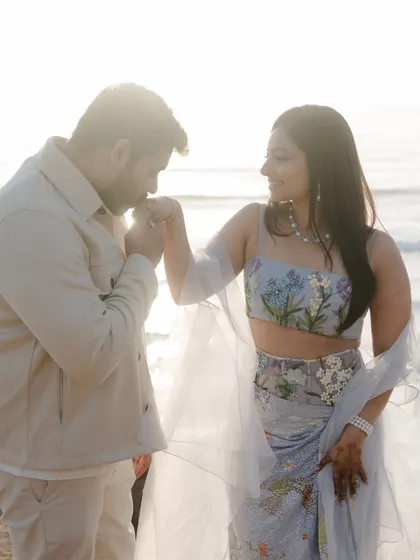 A classic, romantic gesture by the ocean at sunset. This beautifully lit pre-wedding photo is both timeless and heartfelt.