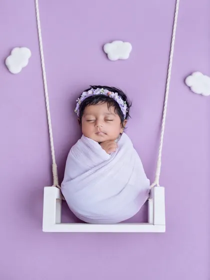 Gently swinging into dreamland. This simple and sweet setup uses a miniature swing and a soft lavender wrap to create a peaceful and adorable portrait.