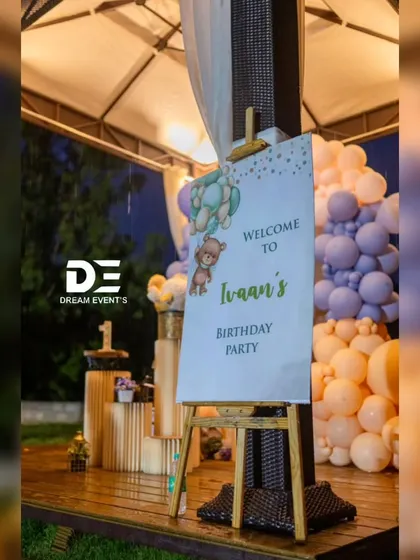 The personalized welcome sign for Ivaan's teddy bear party, greeting guests at the entrance to the charming outdoor venue.