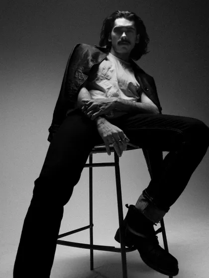 A low-angle, seated shot in black and white that creates a powerful and dramatic mood.