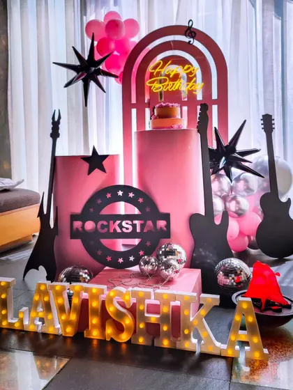 A "Rockstar" theme party, perfect for a girl who's ready to rock her birthday. The setup includes guitar props, a neon sign, and disco balls.