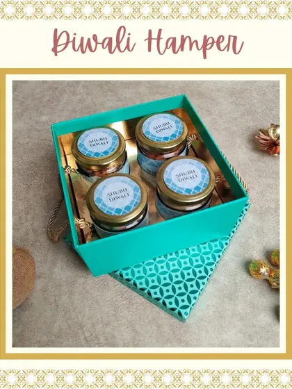 This compact and elegant Diwali gift features four jars of assorted dry fruits and nuts in a beautiful teal tray with a patterned lid. It's a healthy and traditional gifting option.