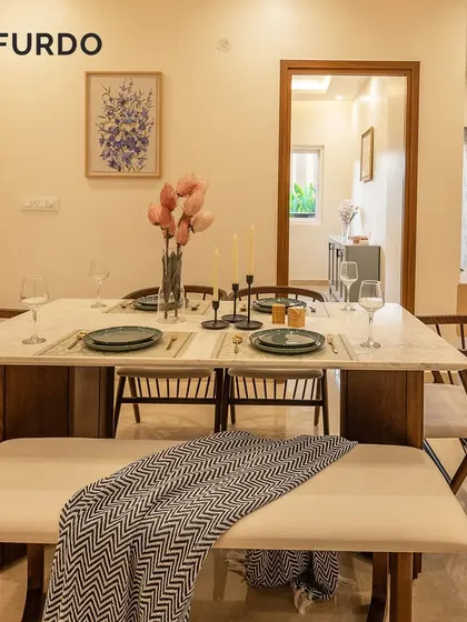 A modern dining setup featuring a marble-top table paired with a comfortable bench and elegant wishbone chairs. This combination offers flexible seating and adds a contemporary touch to the dining experience.