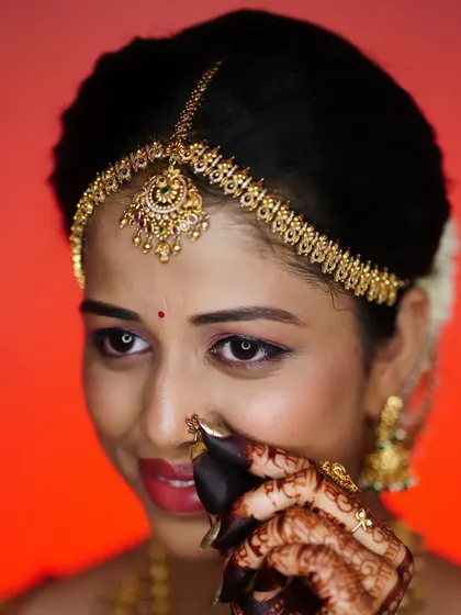 A playful and shy pose from the bride, highlighting her intricate henna and nose ring.