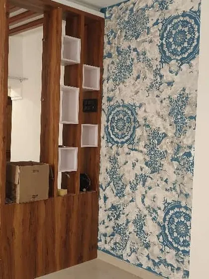 A custom mandala stencil design can beautifully complement your home's interior elements. Here, a blue and white pattern creates a striking accent wall next to a wooden partition, adding a touch of traditional art.