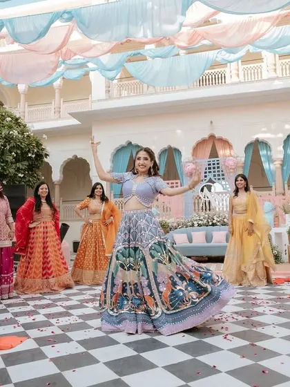 The bride and her squad in the middle of a fun, choreographed routine at her Mehendi. The colorful outfits and outdoor setting create a picture-perfect moment.