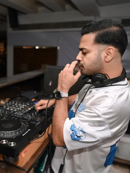 On the mic while keeping a hand on the decks. It's about multitasking to keep the energy flowing.
