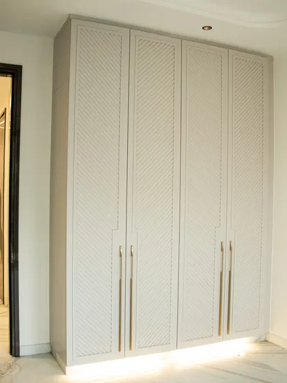 This custom-designed wardrobe fits perfectly into the space, with a subtle texture that elevates the room's aesthetic.