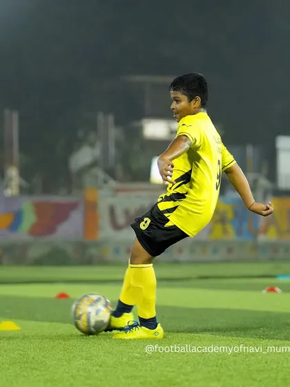 A young player strikes the ball with proper technique during a shooting drill.