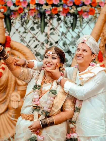 A joyful, candid moment during a traditional wedding ceremony. The couple's happiness is infectious.