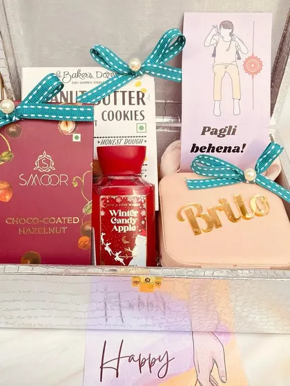 A beautiful trunk box hamper for a sister, filled with cookies, chocolates, and a personalized pouch.