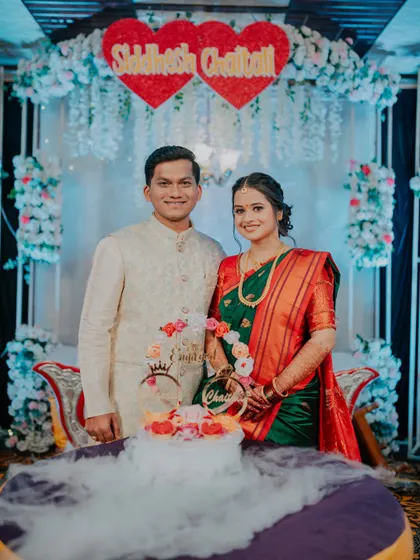 The couple poses for a photo before cutting their engagement cake, which features a dramatic dry ice effect.