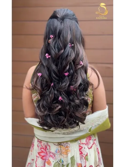 The back view of the baby's breath and curls hairstyle, showing how the flowers are scattered through the hair.