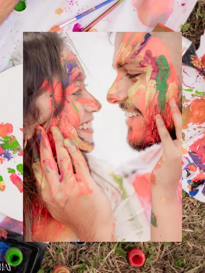 A close-up, intimate shot of the couple's paint-covered faces, full of laughter and love.