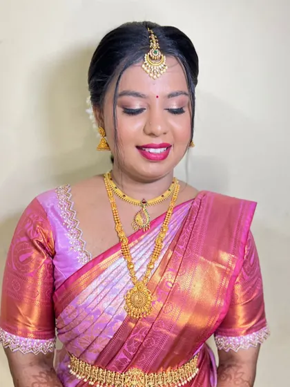 A smiling bride, happy and ready for her big day. The makeup is bright and glowing, with a focus on a beautiful pink lip.