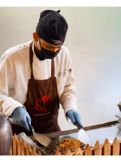 A chef preparing noodles at a live Asian wok station for a pure vegetarian wedding reception.