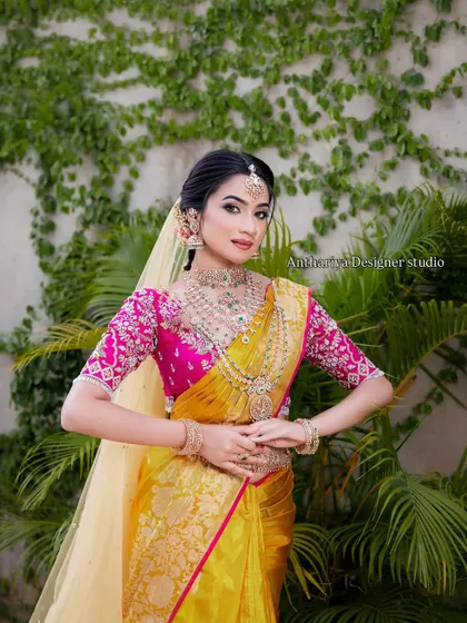 A model showcasing a beautiful yellow Kanjivaram saree with a contrasting rani pink embroidered blouse.