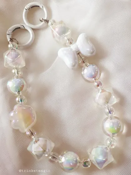 A close-up of the white aesthetic charm, showing the beautiful iridescent and geometric beads that catch the light perfectly.