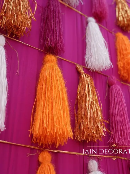 A close-up of the tassel wall, showing the texture and vibrant colors. This simple yet effective decor element adds a huge amount of visual interest and fun to the event.