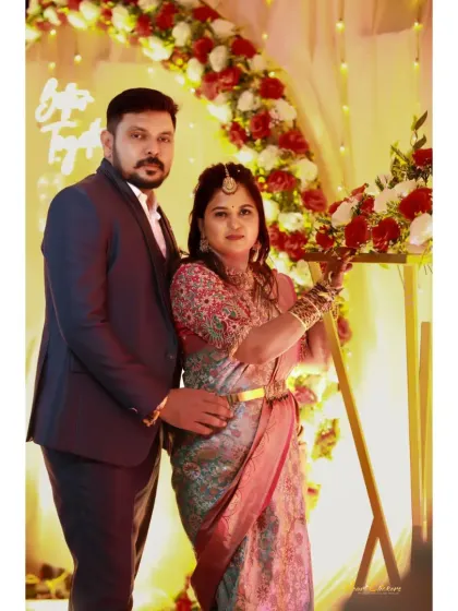 A classic reception portrait of the couple, posed against a beautiful floral backdrop.