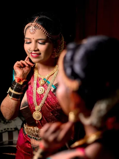 A creative bridal portrait using a mirror to capture the bride's reflection as she gets ready.
