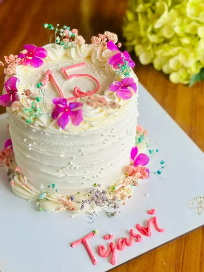 Pretty in petals. This minimal floral cake for a Sweet 16 is adorned with a wreath of fresh, delicate flowers for a celebration that is soft, sweet, and beautiful.