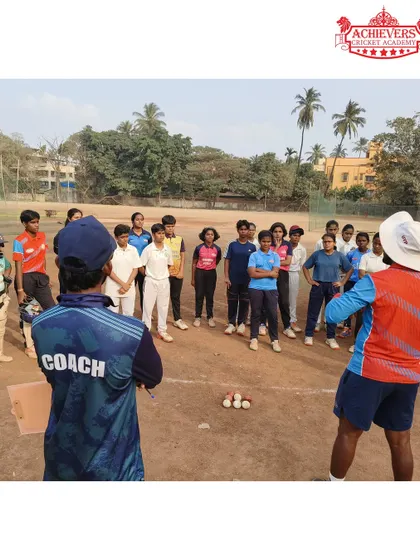 A coach providing guidance to a group of talented girls during the selection process. We aim to build a strong foundation for women's cricket.