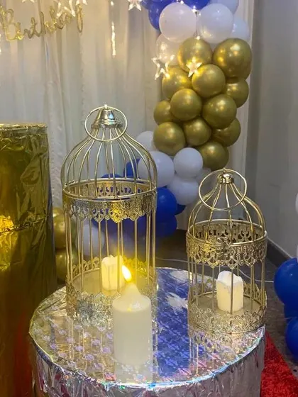 Small details like these golden birdcages with battery-operated candles add a touch of elegance and warmth to the decor. They work beautifully for evening parties and milestone celebrations.